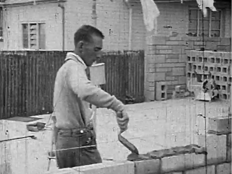Peter J. Daniels laying bricks